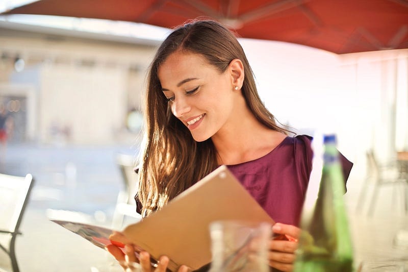 A woman sat at a cafe, reading.